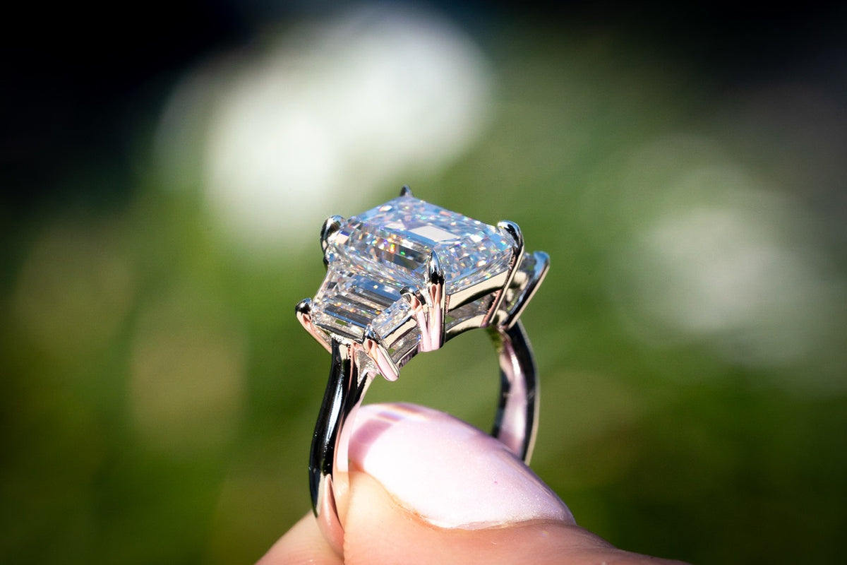 Emerald-cut diamond ring held in natural light