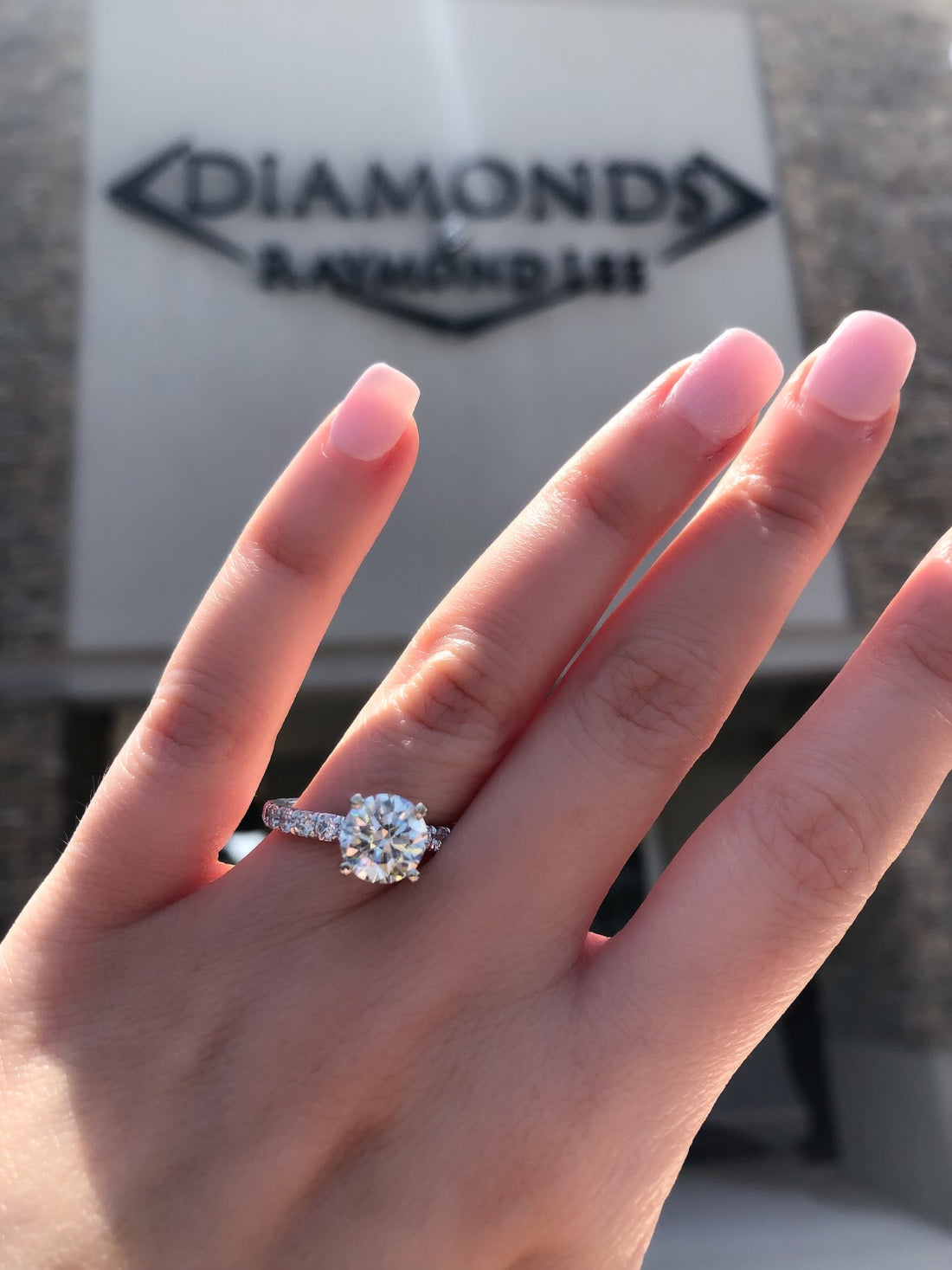 solitaire engagement ring in front of diamonds by raymond lee where you can find how much to spend on an engagement ring