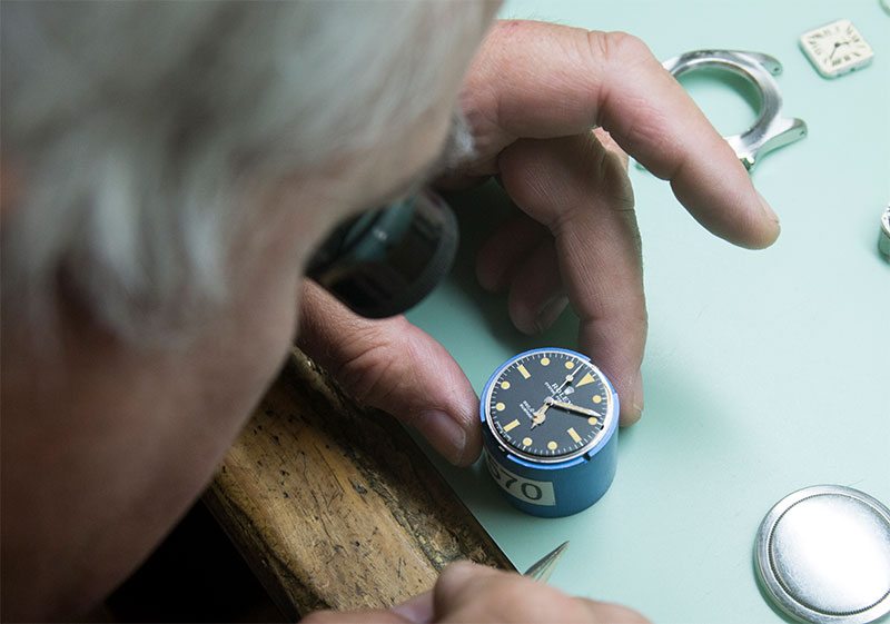 Watchmaker examining a watch movement at the workbench