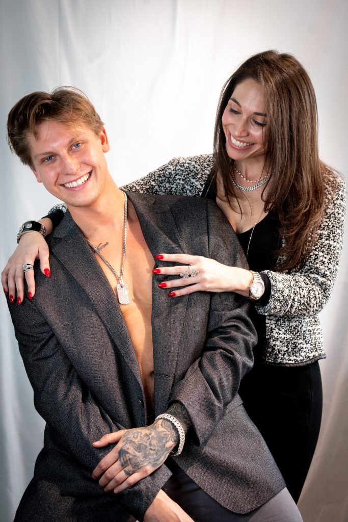 Smiling couple wearing diamond jewelry and luxury watches