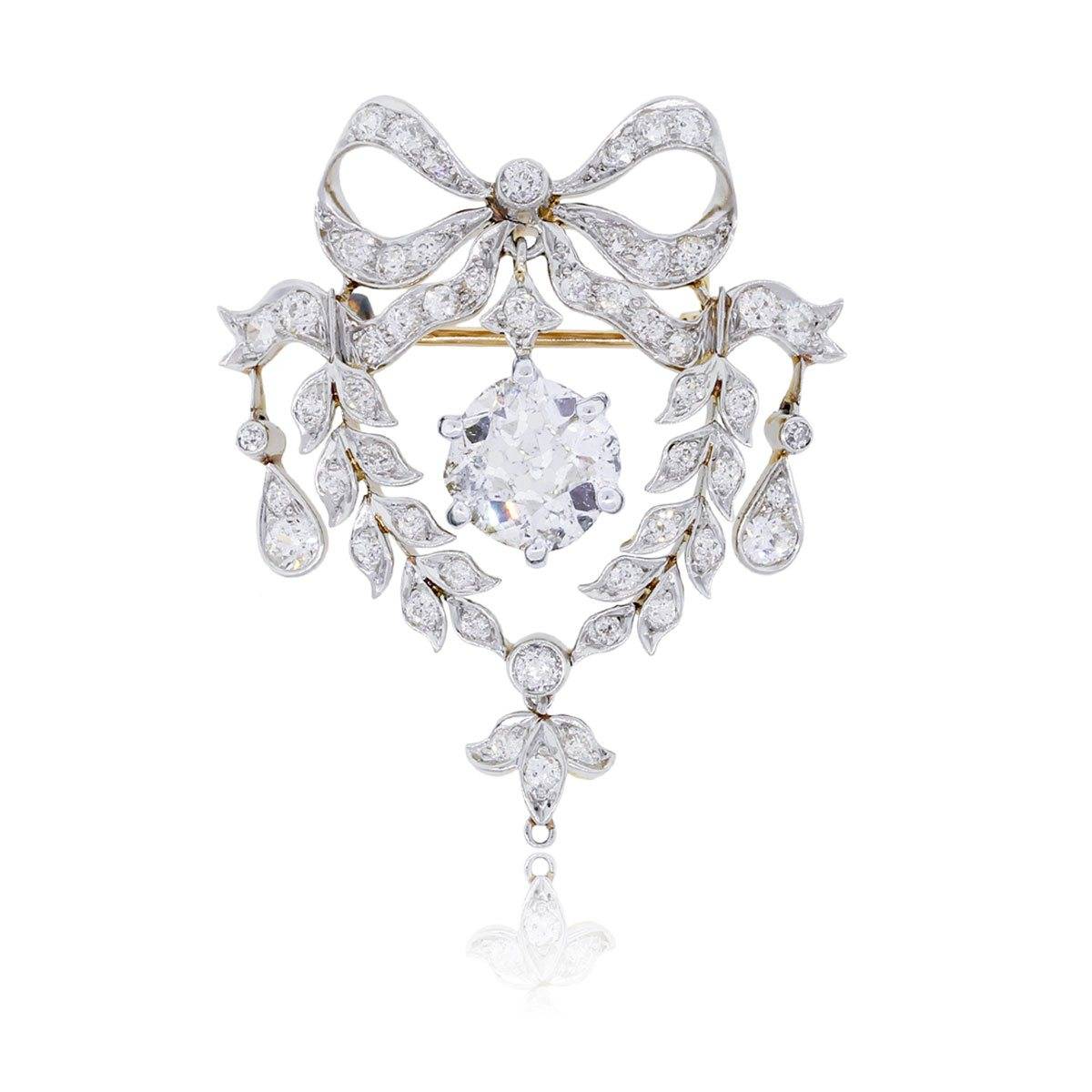 This amazing antique diamond brooch features a true cushion cut diamond center.