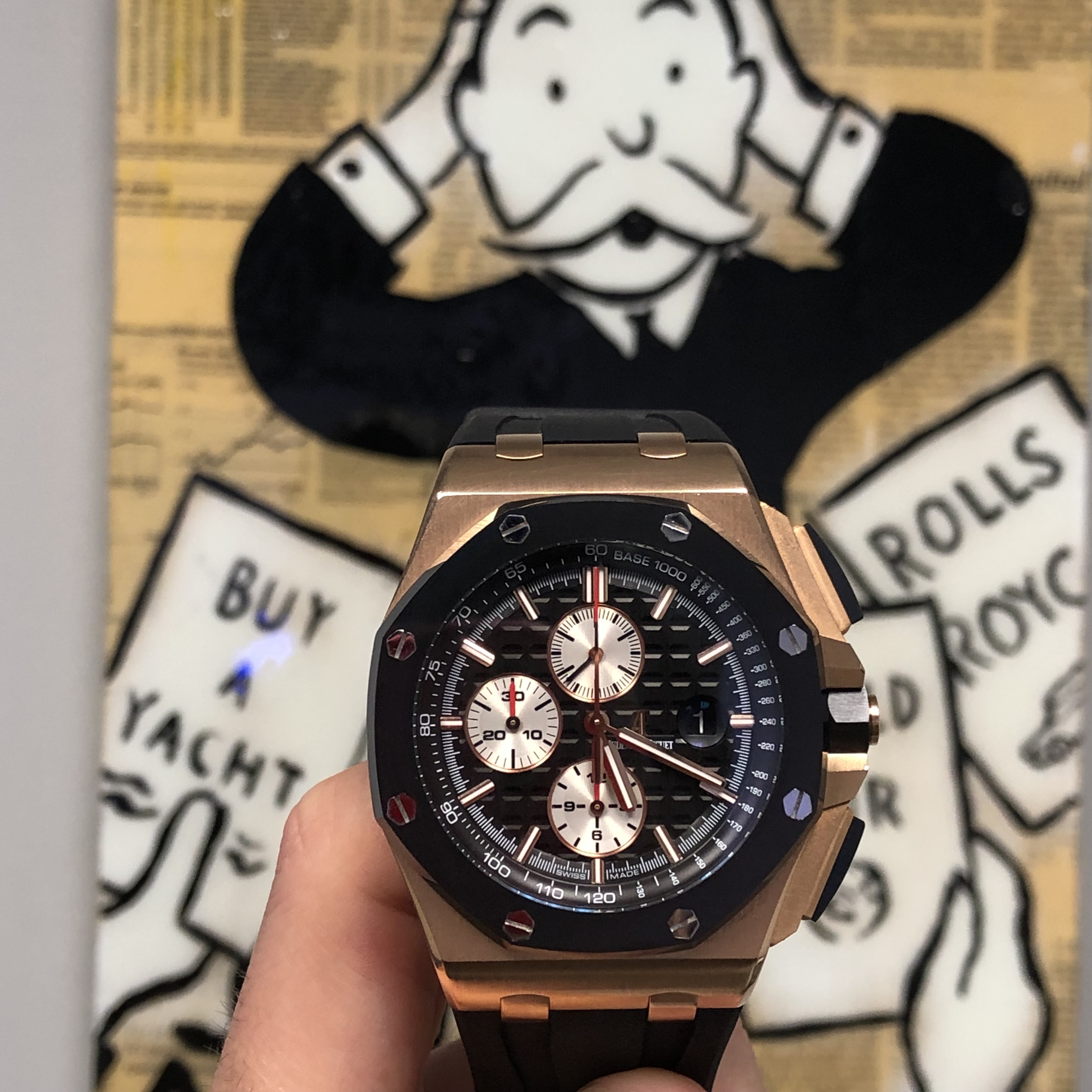 audemars piguet royal oak offshore rose gold rubber clad watch with Monopoly man in the background