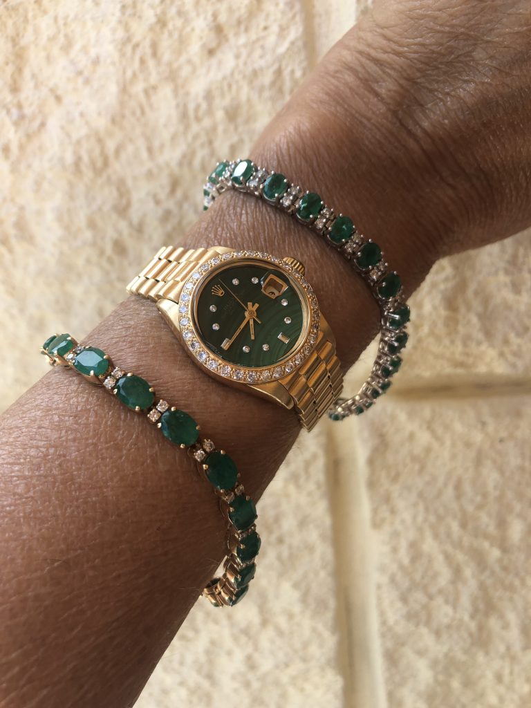 yellow gold emerald and diamond bracelet and rolex datejust green malachite dial on wrist