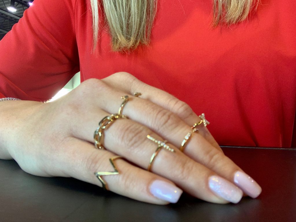 up close of woman's hand wearing gold jewelry 