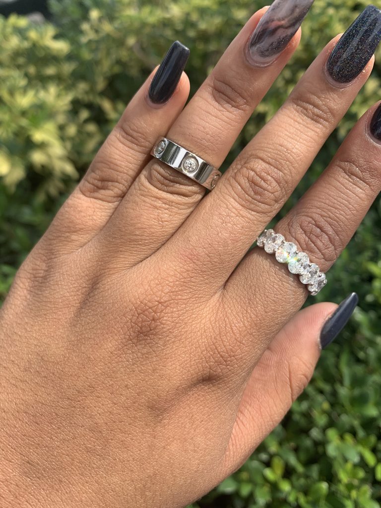 cartier love ring worn alongside oval cut diamond band