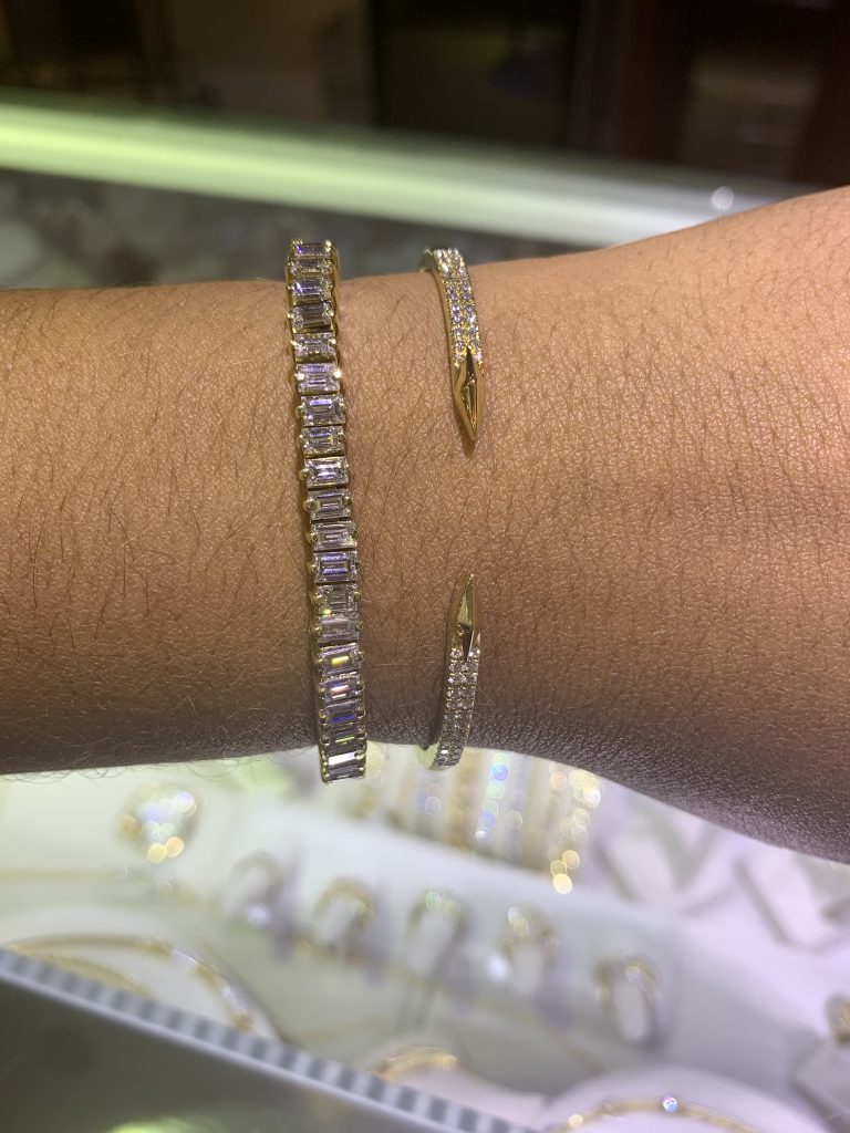 diamond bracelets showing why jewelry is the best gift in front of glass case of fine jewelry