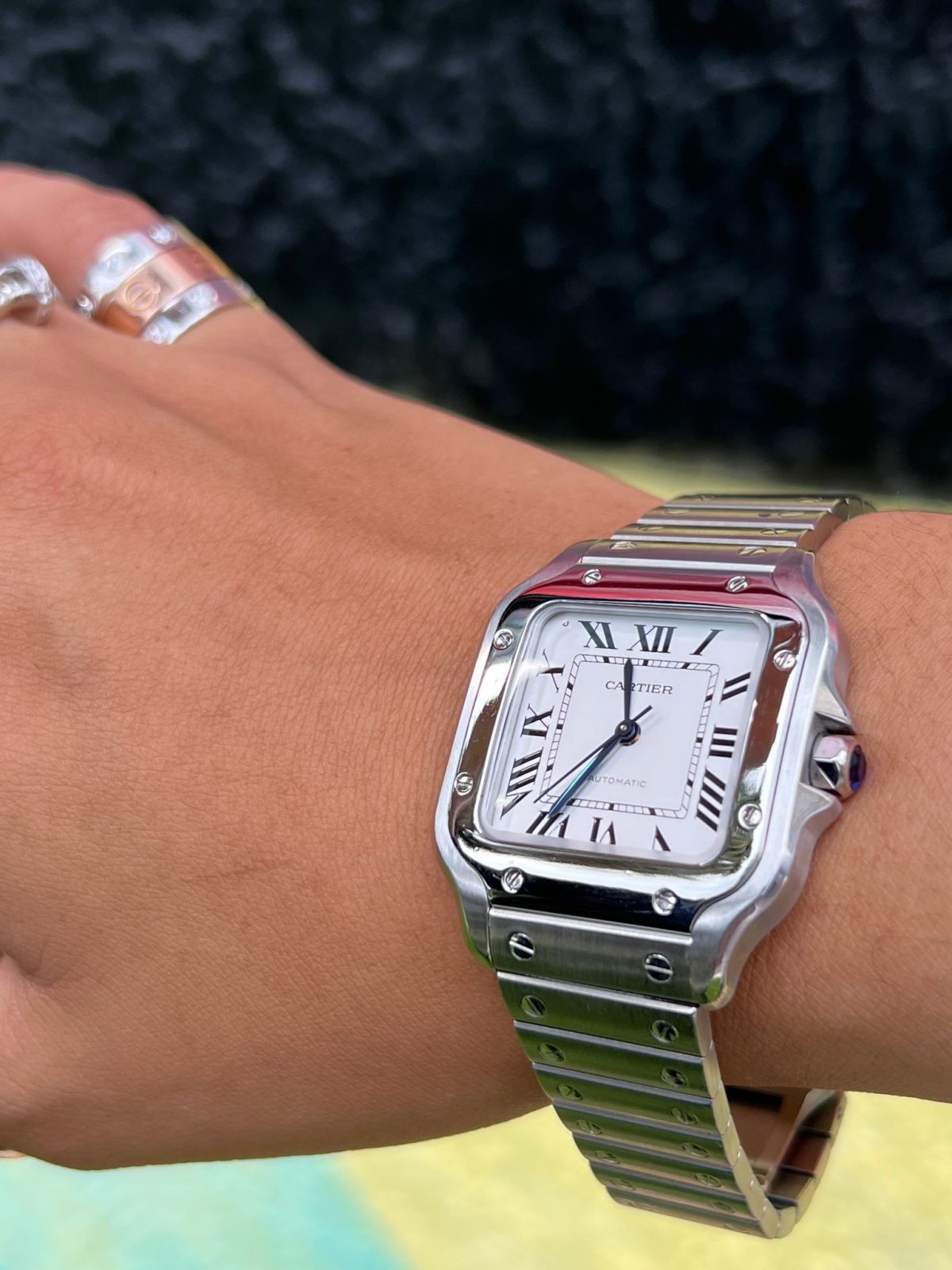 a Santos De Cartier watch on the wrist